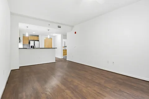 a view of a kitchen with wooden floor and a window