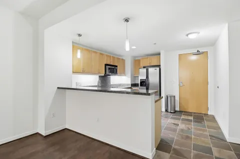 a kitchen with stainless steel appliances granite countertop a refrigerator a sink a stove a microwave and island