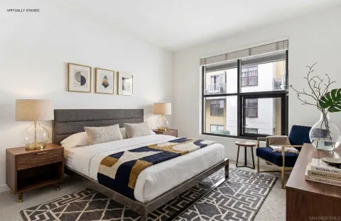 a bedroom with bed and a large window
