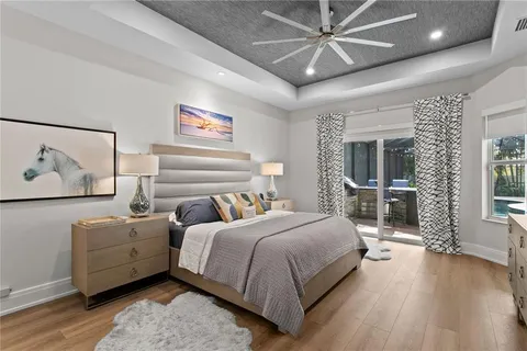 a bedroom with a large bed a chandelier and dresser