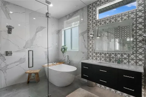 a bathroom with a double vanity sink toilet mirror and bathtub