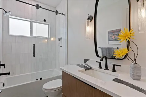 a bathroom with a sink a toilet and shower
