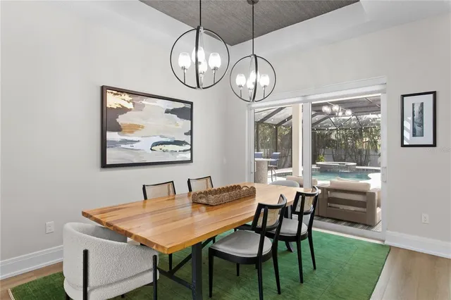 a view of a dining room with furniture a chandelier and wooden floor