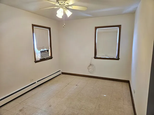 an empty room with a fan and a window
