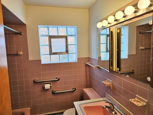 a bathroom with a toilet a sink and mirror