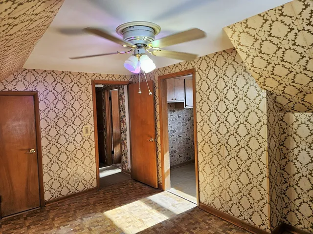 a view of a hallway with wooden floor and chandelier