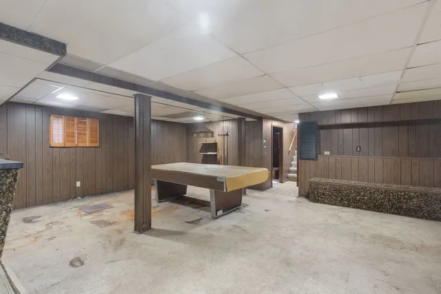 a spacious bedroom with a large bed and a chandelier