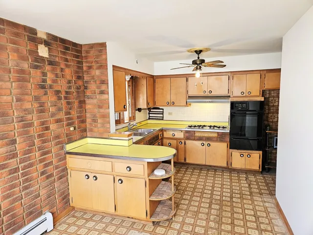 a kitchen with a sink a stove cabinets and a dining table