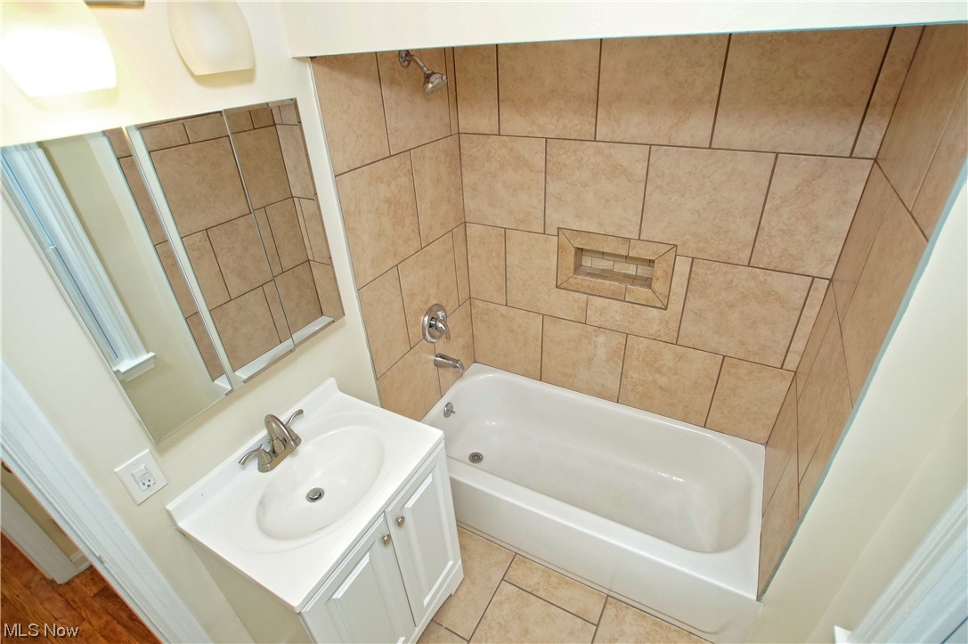1387 Winston Road Cleveland, OH 44121 - Photo 22 of 29 Bathroom with tiled shower / bath combo, oversized vanity, and wood-type flooring