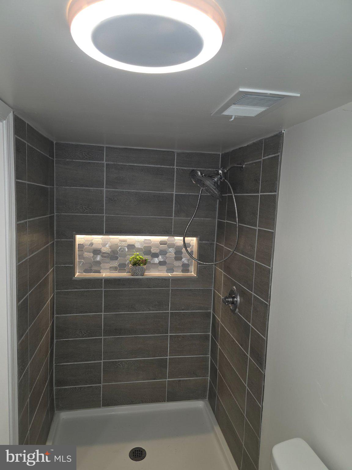 3712 West Cold Spring Lane Baltimore, MD 21215 - Photo 22 of 39 Sleek modern shower with stylish tiles.