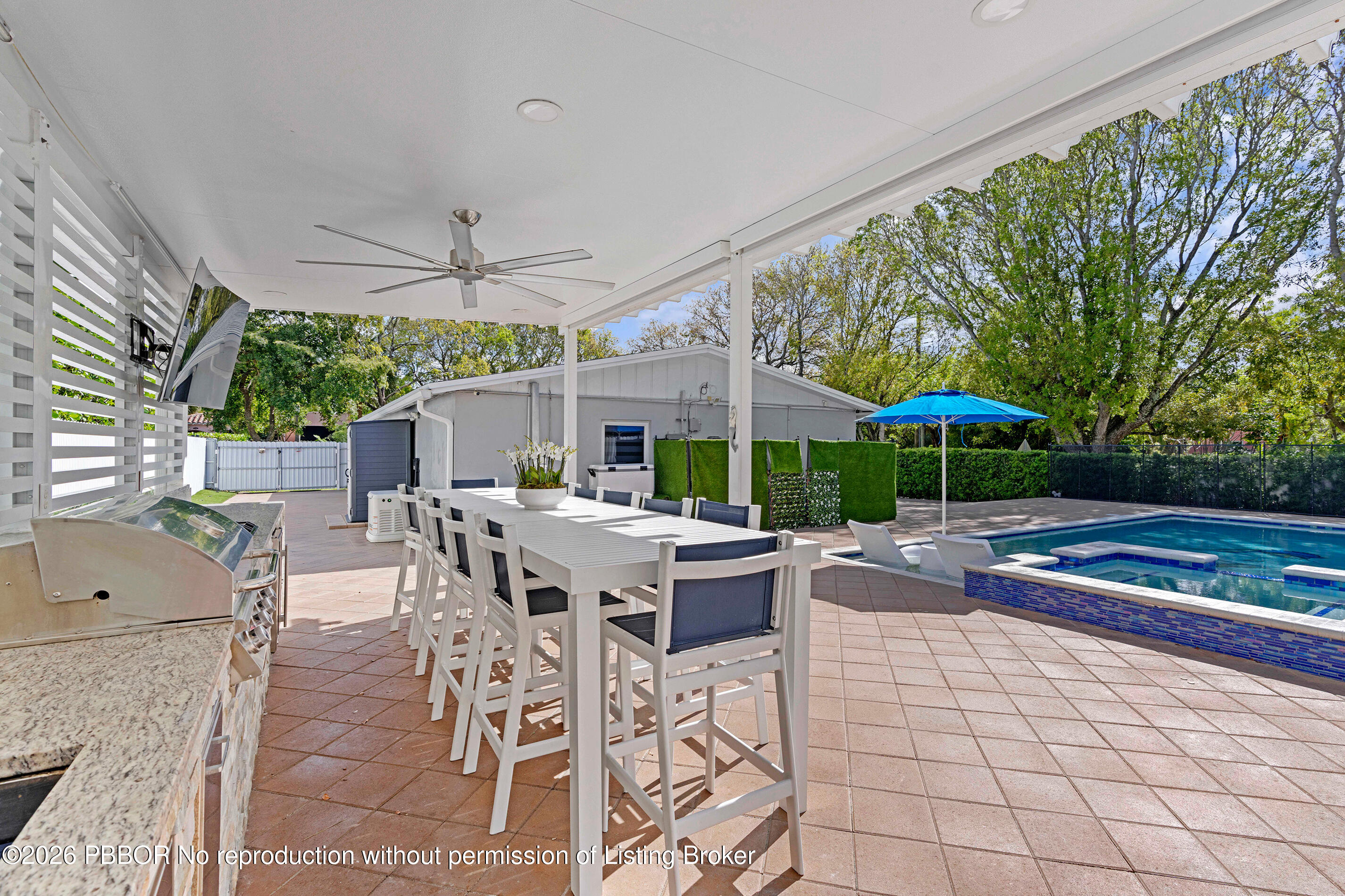 747 Avon Road West Palm Beach, FL 33401 - Photo 20 of 29 a view of a patio with a dining table and chairs under an umbrella