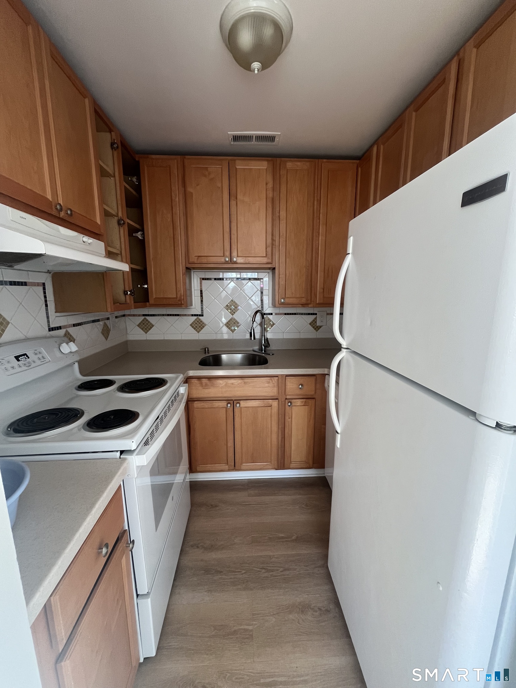 31 Stuart Avenue, Unit 12 Norwalk, CT 06850 - Photo 12 of 15 a kitchen with a white stove top oven and refrigerator