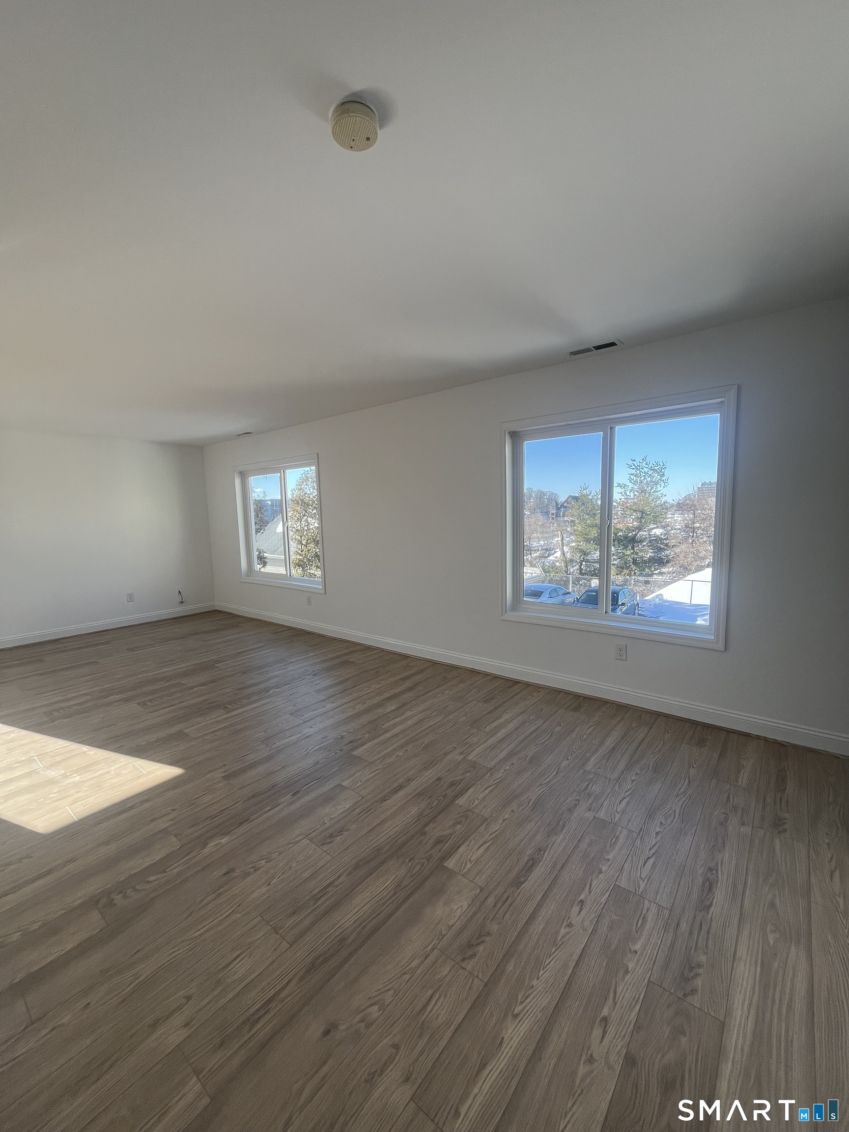 31 Stuart Avenue, Unit 12 Norwalk, CT 06850 - Photo 3 of 15 an empty room with wooden floor and windows