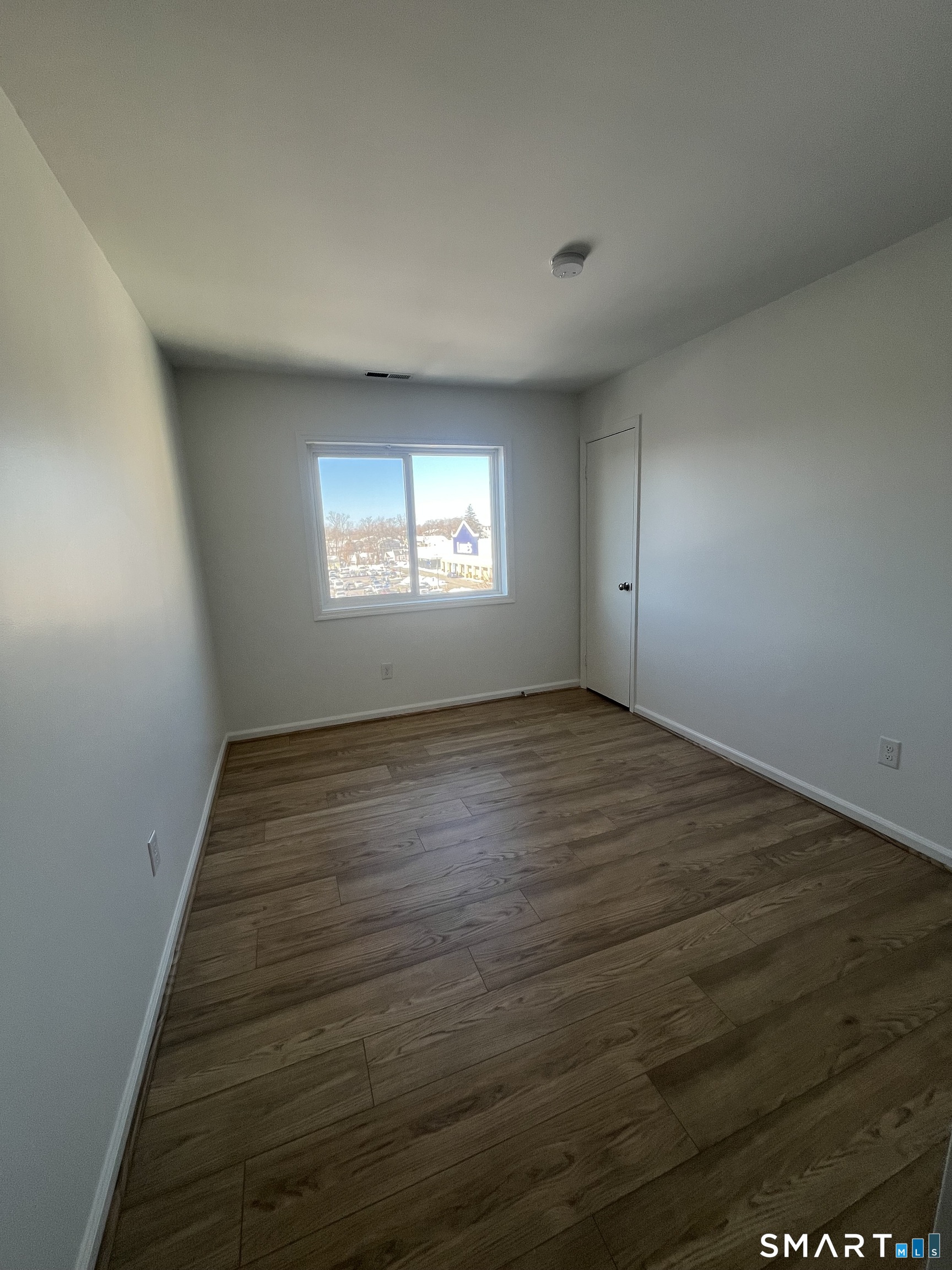 31 Stuart Avenue, Unit 12 Norwalk, CT 06850 - Photo 4 of 15 an empty room with wooden floor and windows