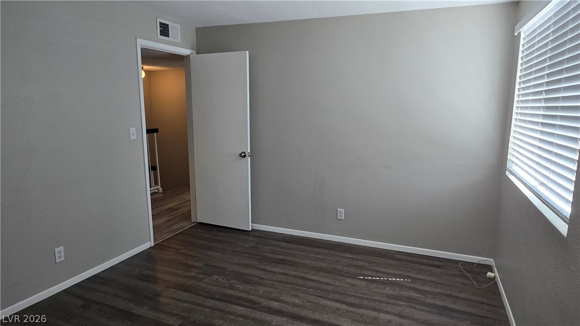 3849 Reflection Way Las Vegas, NV 89147 - Photo 19 of 25 An empty room showcasing durable flooring and ample natural light from a louvered window.