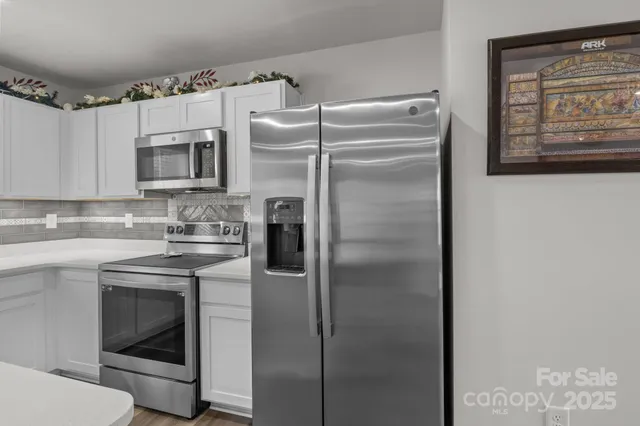 a kitchen with stainless steel appliances granite countertop a refrigerator and a stove top oven