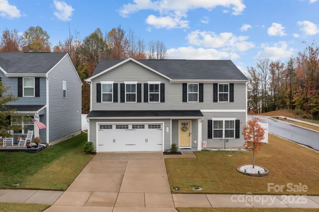 a view of a big house with a big yard and large trees