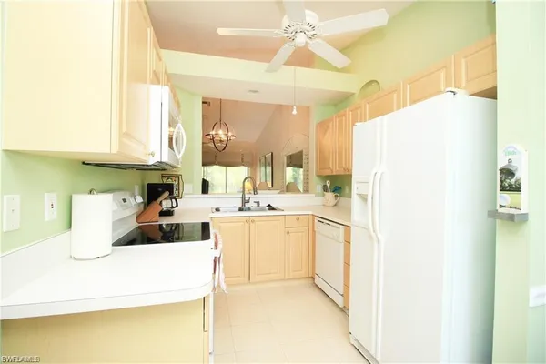 a kitchen with a sink a refrigerator and cabinets