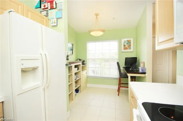 a picture of a room with a fridge and wooden floor