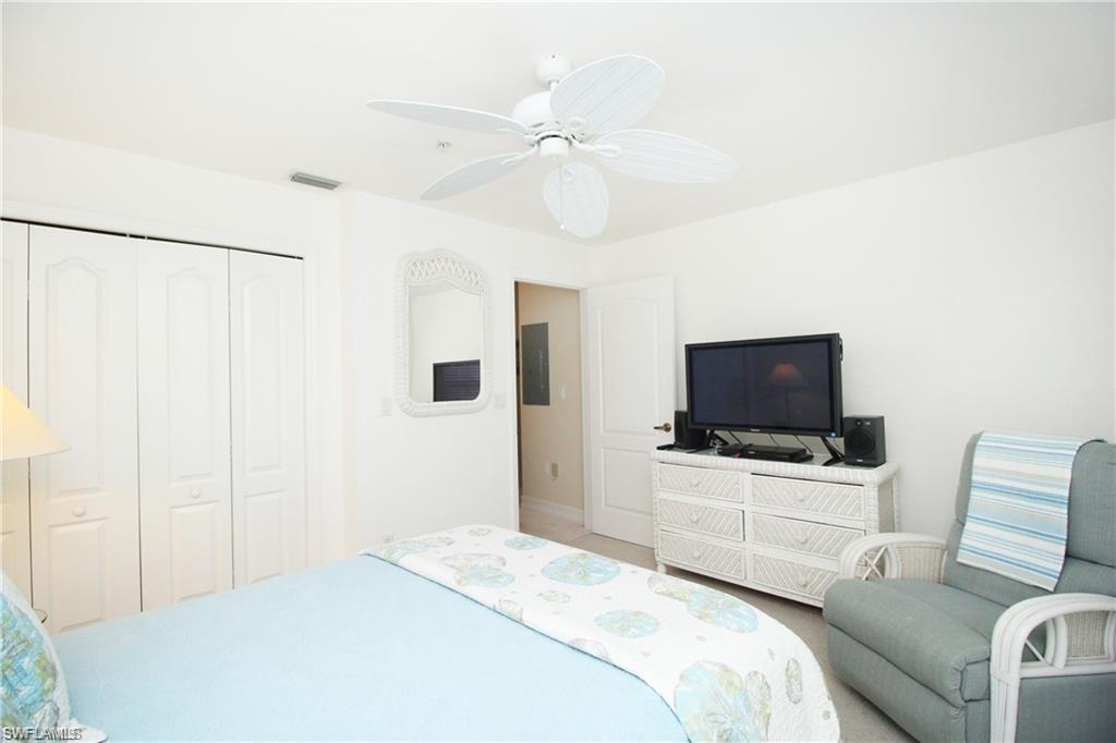 2925 Cypress Trace Circle, Unit 201 Naples, FL 34119 - Photo 10 of 50 a bedroom with a bed and a flat screen tv