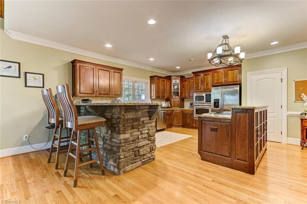 4905 Leadenhall Road Oak Ridge, NC 27310 - Photo 7 of 30 Kitchen bar accented with chiseled edge granite is perfect for entertaining.