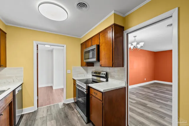 a kitchen with stainless steel appliances a stove a microwave and cabinets