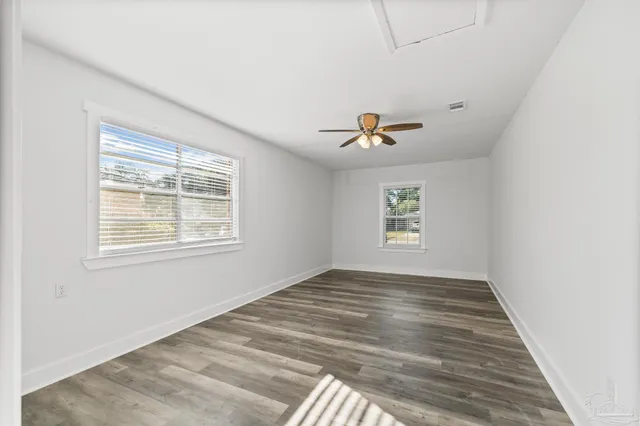 a view of a room with wooden floor and ceiling fan