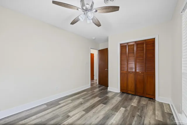 an empty room with closet and windows