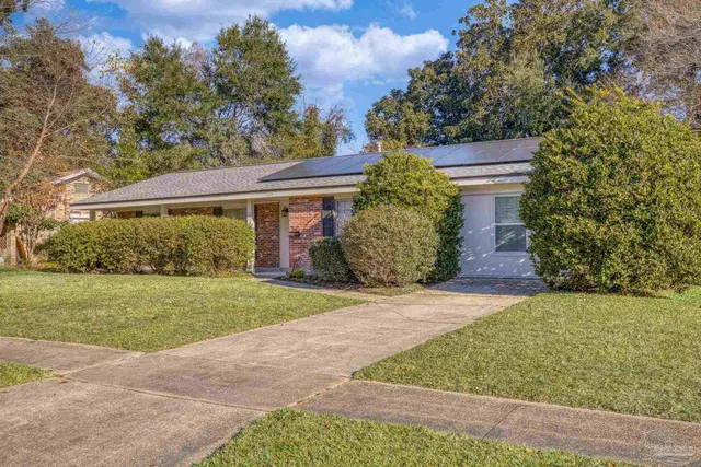 a view of a house with a big yard and large trees
