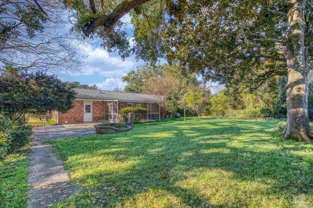 a backyard of a house with plants and large trees