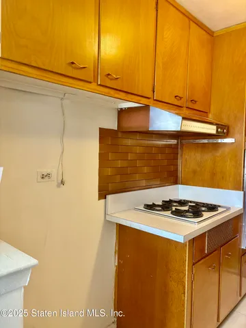 a white kitchen with sink a stove and a refrigerator