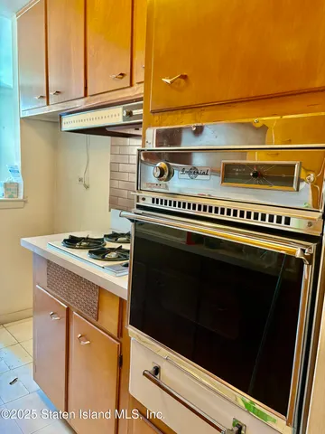 a stove top oven sitting inside of a kitchen