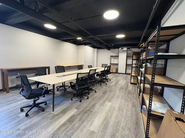 a view of a hall with dining room and wooden floor