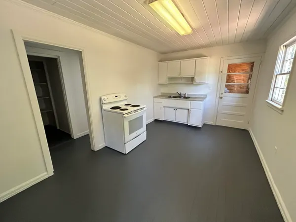 a kitchen with stainless steel appliances a stove top oven a sink a chimney and a refrigerator