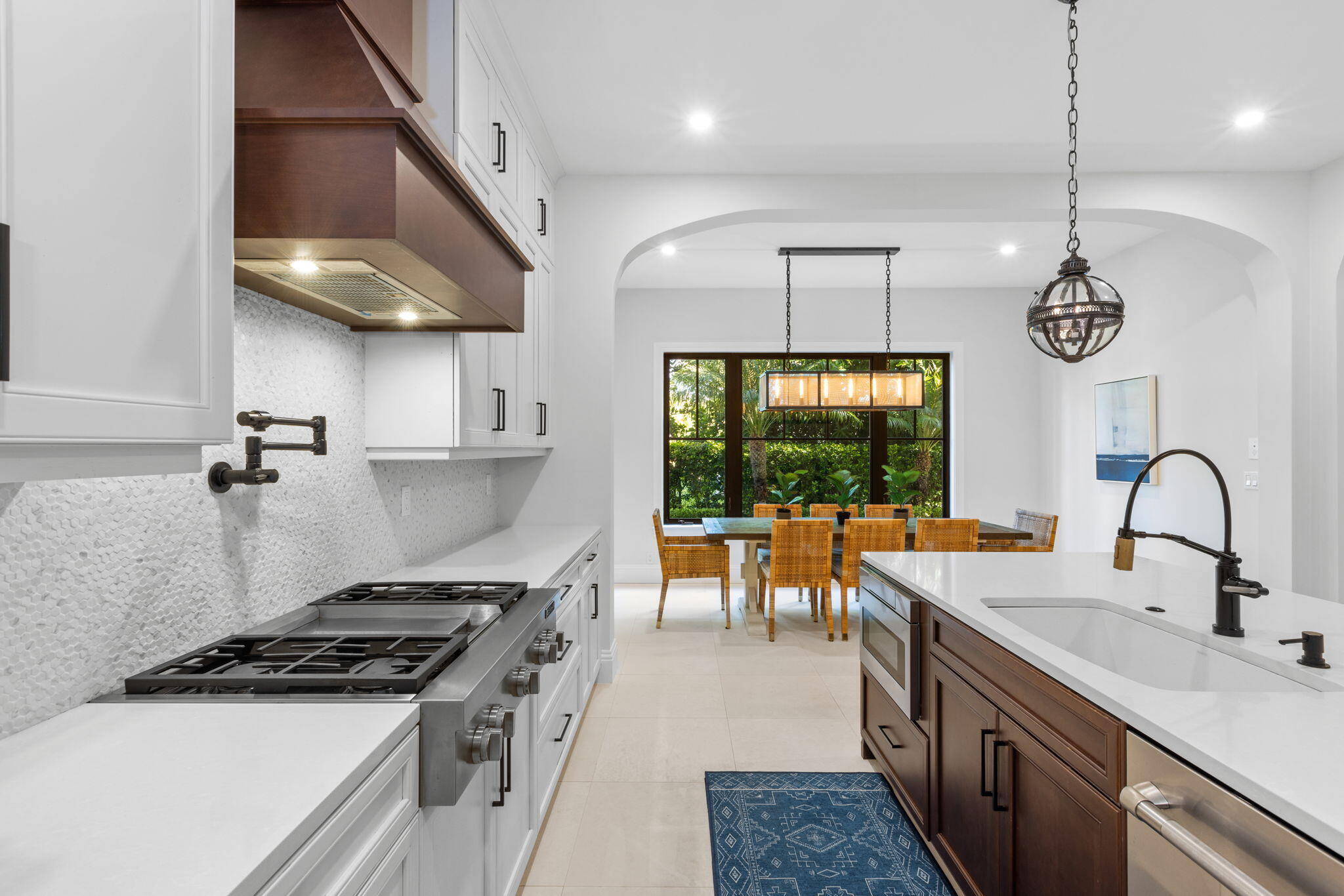 249 Edmor Road West Palm Beach, FL 33405 - Photo 10 of 49 a kitchen with stainless steel appliances granite countertop a stove a sink a refrigerator a stove and a dining table with wooden floor