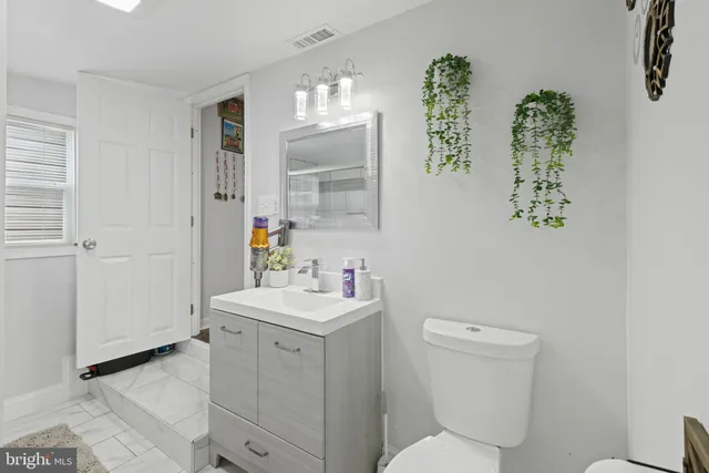 a bathroom with a toilet sink and mirror