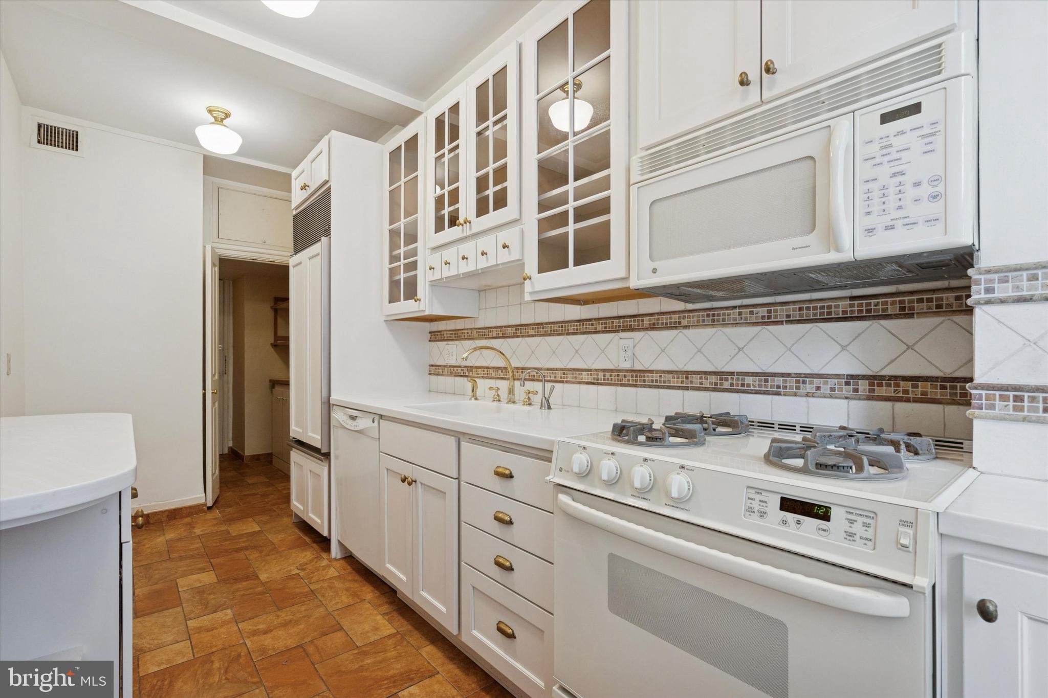 1900-00 Rittenhouse Square, Unit 3C Philadelphia, PA 19103 - Photo 11 of 25 a kitchen with white cabinets and white appliances
