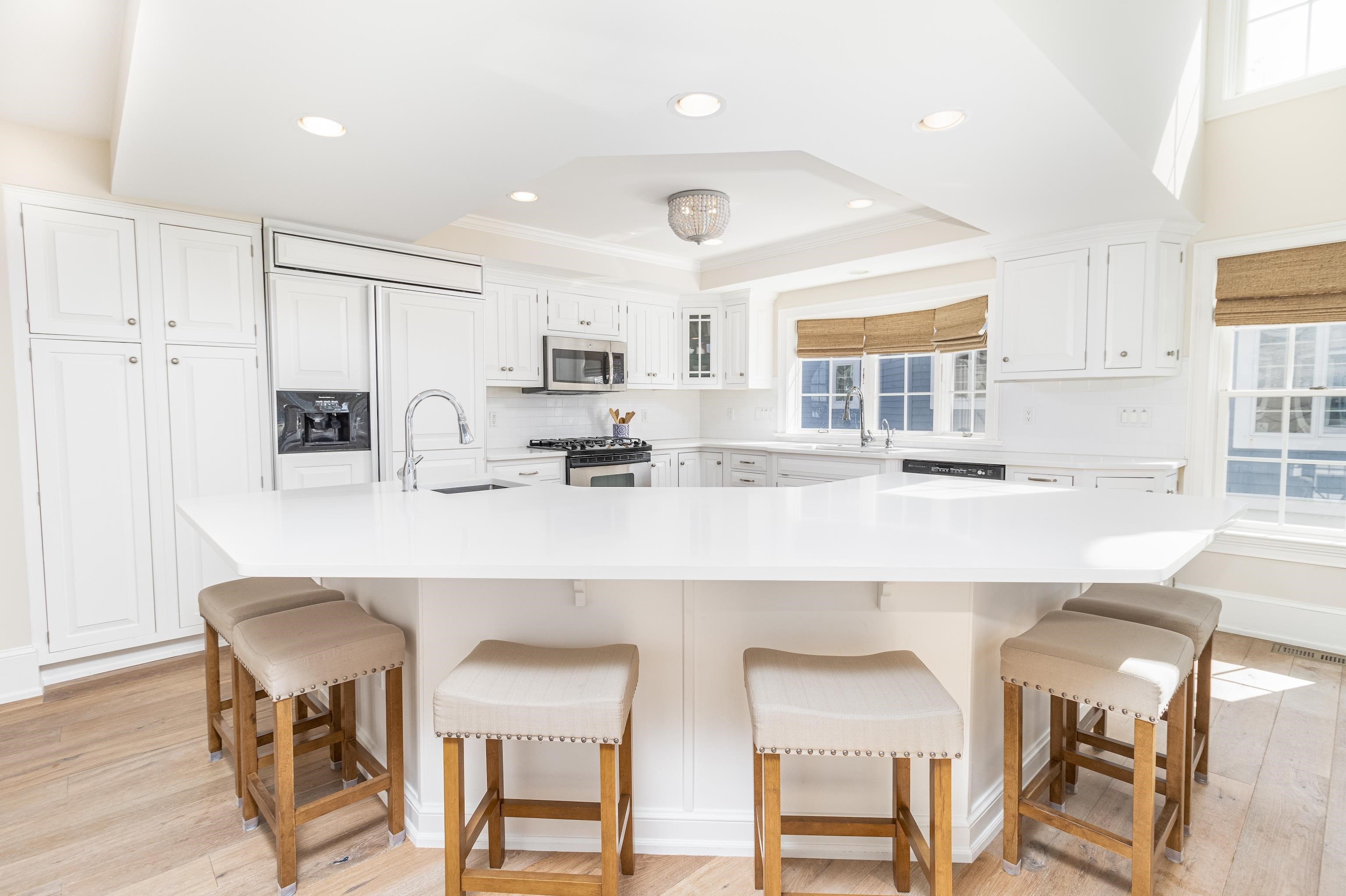 153 76th Street Avalon, NJ 08202 - Photo 19 of 33 a kitchen with stainless steel appliances granite countertop a table chairs refrigerator and sink