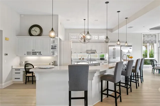 a large kitchen with kitchen island granite countertop a sink a counter space and stainless steel appliances