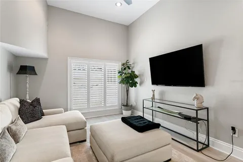 a dining room with furniture large windows and wooden floor