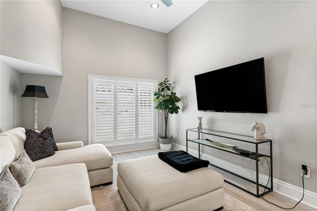 a dining room with furniture large windows and wooden floor