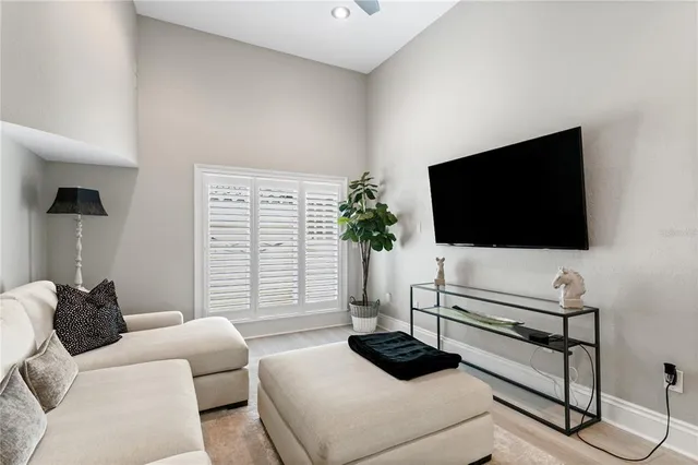 a dining room with furniture large windows and wooden floor