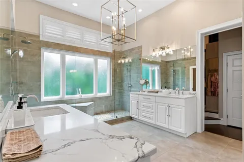 a bathroom with a double vanity sink window and a mirror