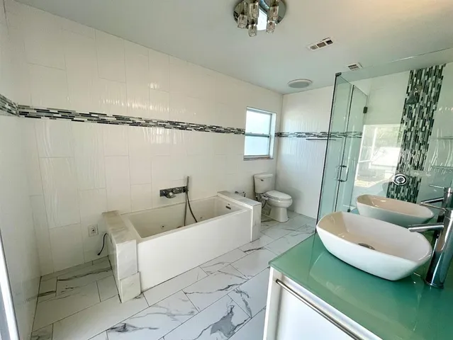 a bathroom with a sink a toilet and shower