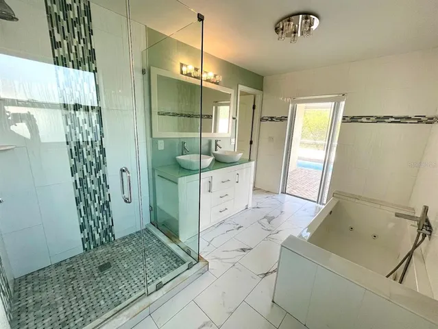 a bathroom with a double vanity sink mirror and shower
