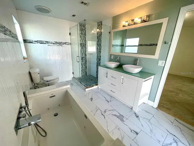 a bathroom with a bathtub sink and mirror