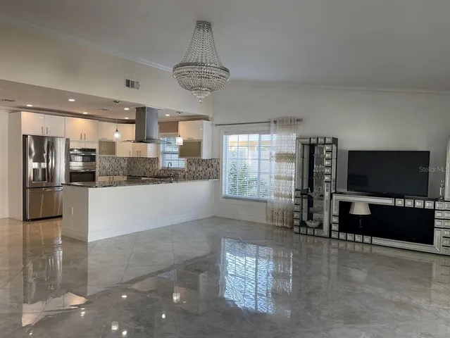 a kitchen with stainless steel appliances granite countertop a refrigerator and a stove top oven