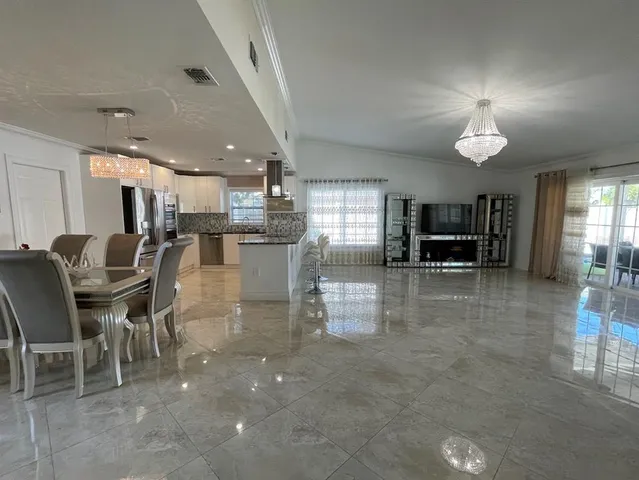 a kitchen with stainless steel appliances a table and chairs in it