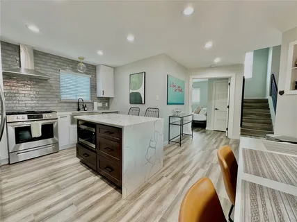 a large kitchen with stainless steel appliances granite countertop a stove and a sink