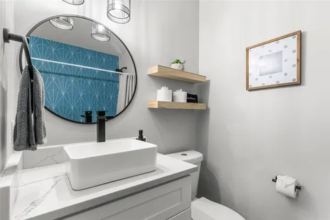 a bathroom with a sink mirror and toilet